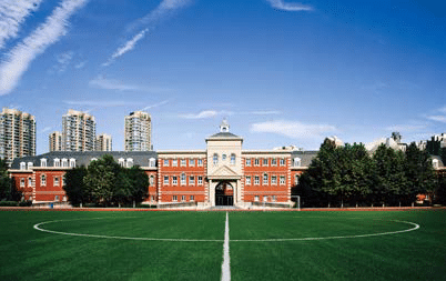 Wellington College International Tianjin campus behind a green sports pitch