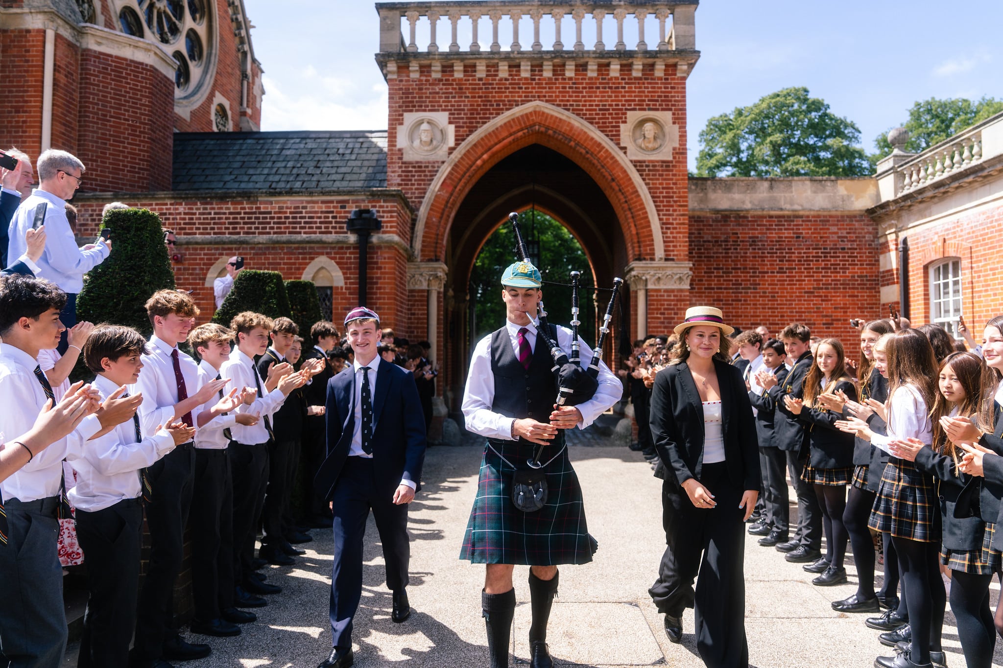 A pipe band procession with pupils in kilts