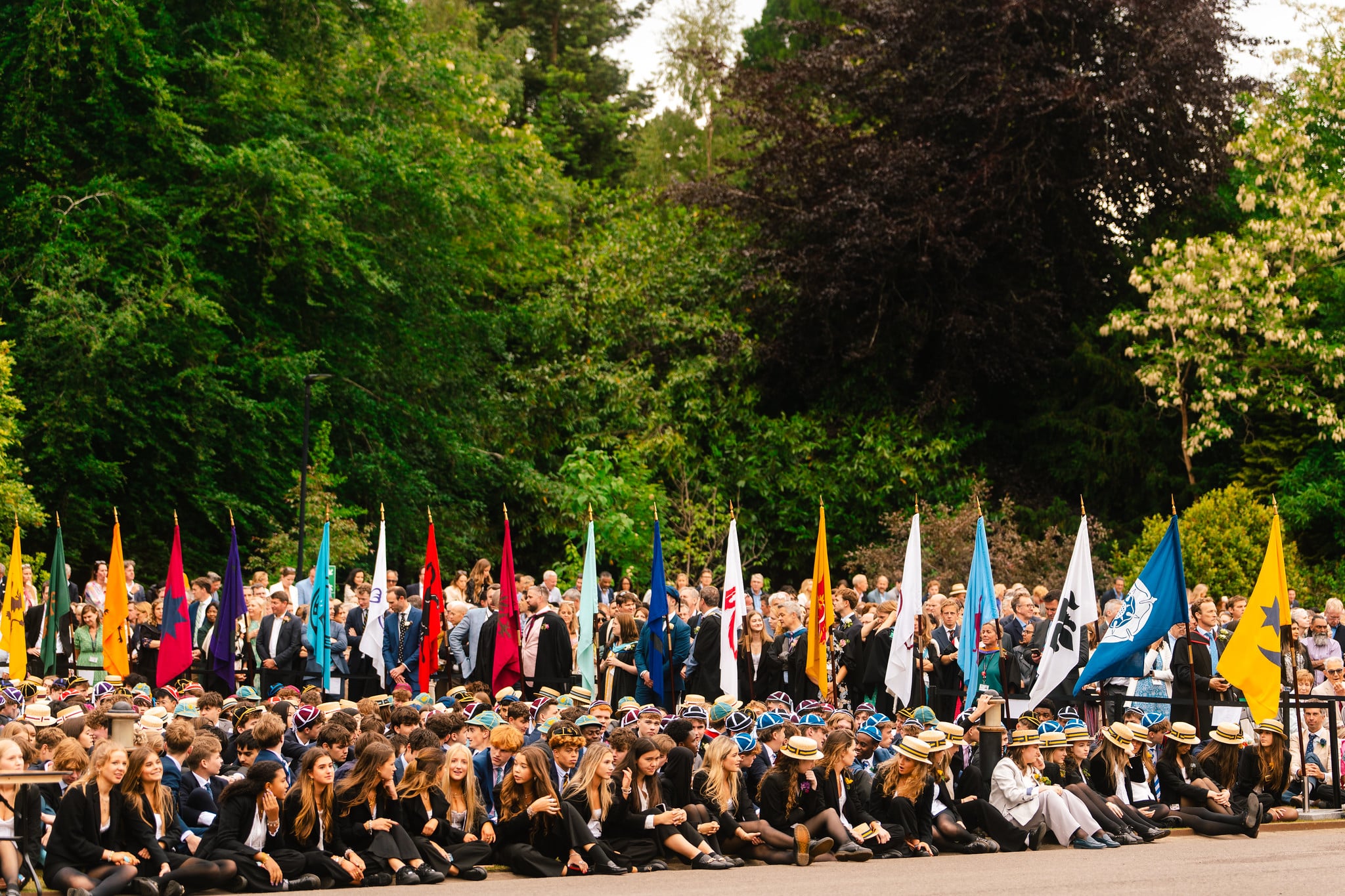 Whole-school photograph of Wellington College pupils with house flags on the lawn