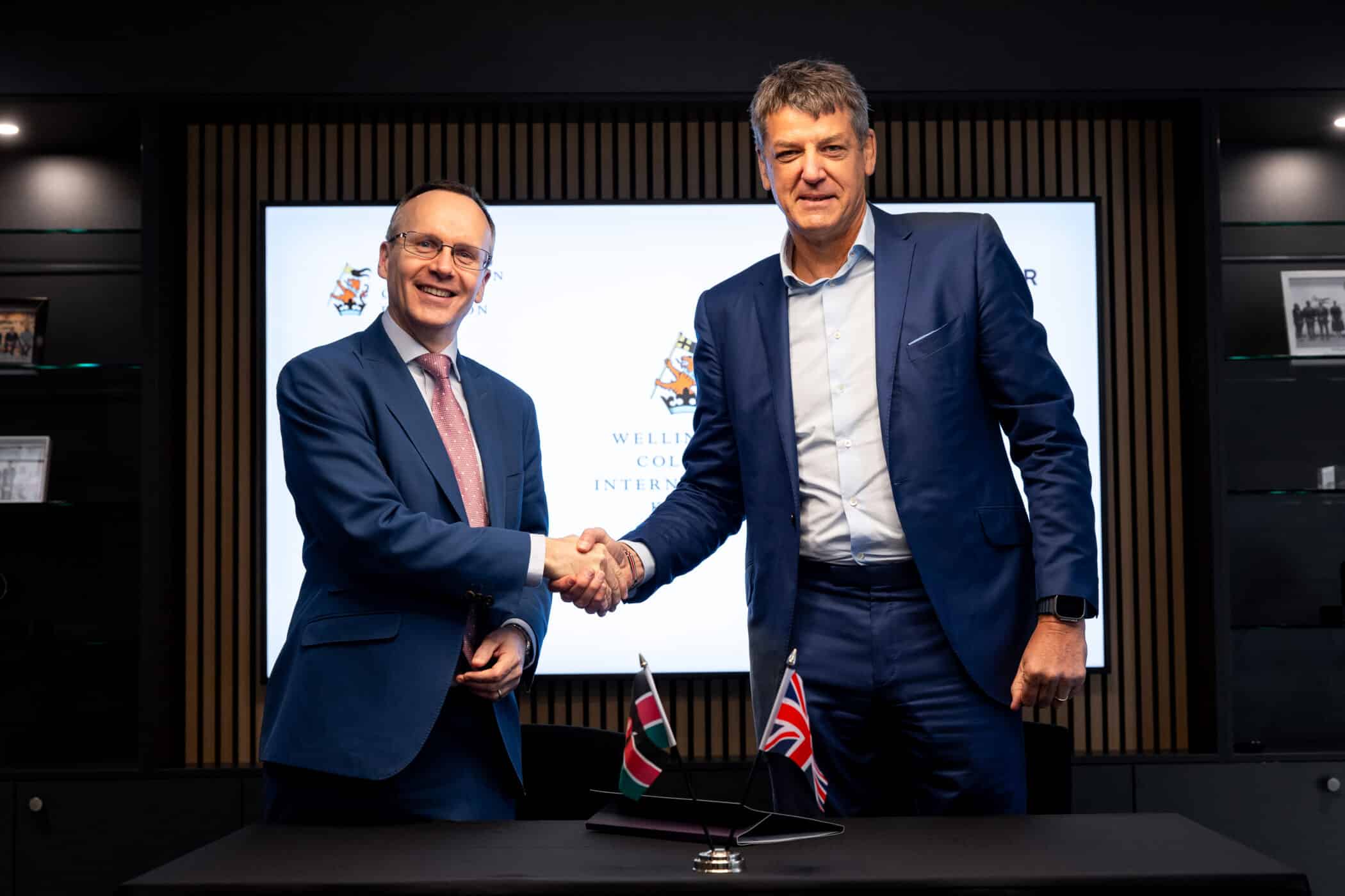Two people shaking hands at a partnership signing