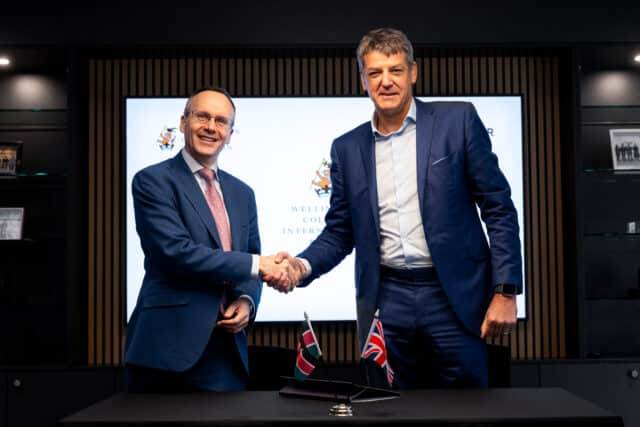 Two people shaking hands at a partnership signing